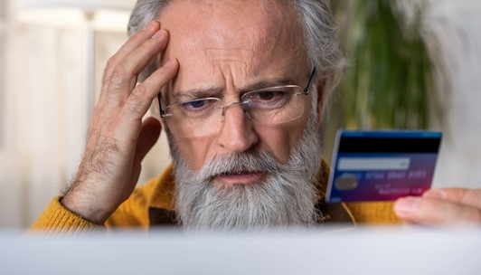 Man holding credit card looking upset